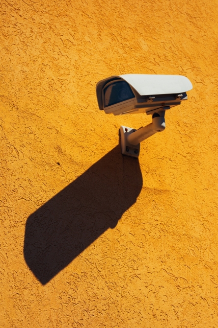 Security camera on yellow wall